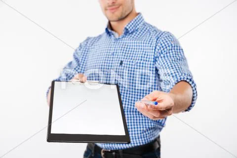 Handsome man architect in hard hat giving you blank clipboard Stock Photos