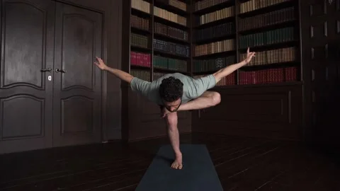 Handsome Man Balancing On One Leg Doing Yoga at Home Stock Footage 152566937