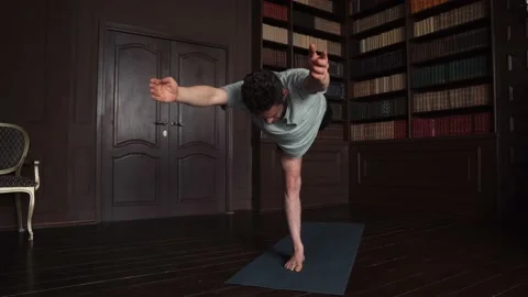 Handsome Man Balancing On One Leg Doing Yoga In Apartment Stock Footage 152567201