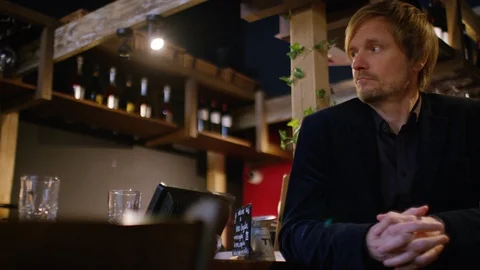 Handsome man at a bar by himself waiting for someone Stock-Footage 102283772