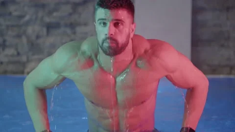 Handsome man bathing in slow motion at luxury pool indoor. Video stock 239554210