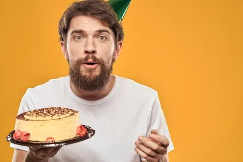 Handsome man with a beard and in a cap celebrating a birthday party yellow Stock Photos