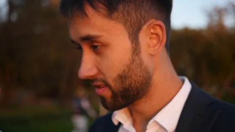 A handsome man with a beard and in a jacket dictates something on the phone. HD Stock Footage 117427135