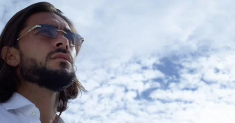 Handsome man with a beard and long brown hair in close view. He is wearing glass Stock Footage 154693897