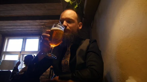 Handsome man with beard cheering and drinking non alcoholic beer in rustic Stock Footage 124878032