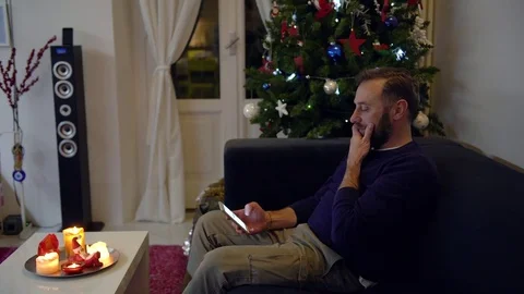 Handsome man with a beard interacting with his mobile phone with a Christmas  Stock Footage 78707365
