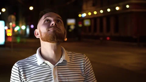 Handsome man with beard look up and then in camera. Dressed in striped shirt and Stock Footage 112829558