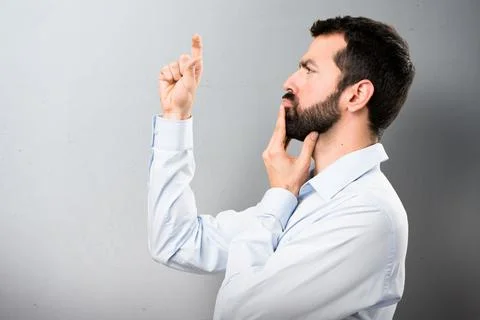 Handsome man with beard making tiny sign on textured background Foto stock