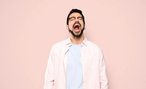 Handsome man with beard shouting to the front with mouth wide open Photos