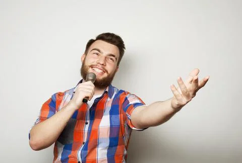 Handsome man with beard singing with microphone Stock Photos