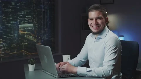 Handsome man with beard smiling to the camera while working on the computer Stock Footage 157594530