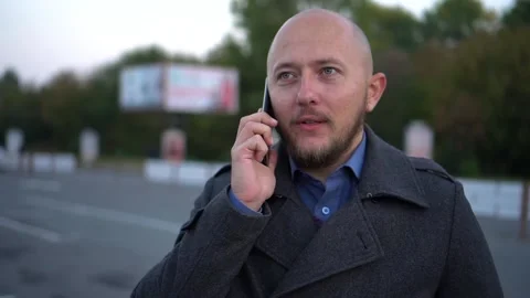 Handsome man with beard talking on cellphone. Blury steady shot Stock Footage 97117415