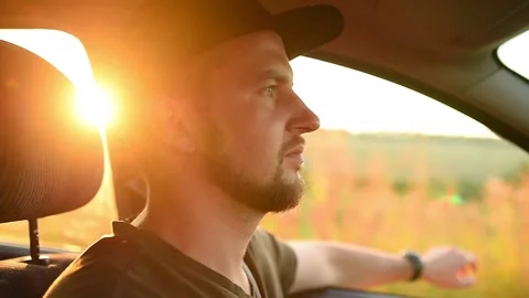 Handsome man in a black cap confidently drives a car. Stock-Footage 138155855