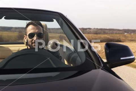 Handsome man on a black classic motorcycle Stock Photos