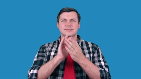 Handsome man on blue background claps his hands Stock Footage 147454891