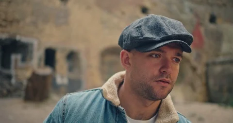Handsome man in blue jeans jacket and white shirt, stylish hat looking around ri Stock Footage 117416335