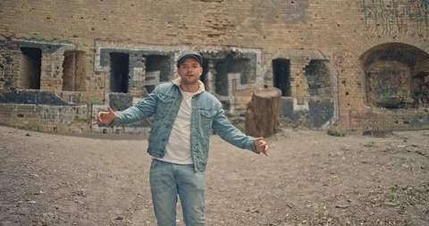 Handsome man in blue jeans jacket and white shirt dancing and having fan on came Stock Footage 117416702
