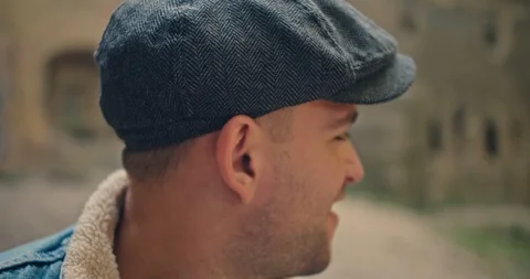 Handsome man in blue jeans jacket and white shirt, stylish hat looking around ri Stock Footage 117417206