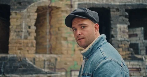 Handsome man in blue jeans jacket and white shirt, stylish hat looking around ri Stock Footage 117418353