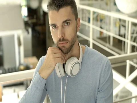 Handsome man in blue sweater doing serious look to the camera, steadycam shot Stock-Footage 80184545