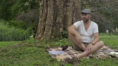 A handsome man with a book on the grass. Stock Footage 65762279
