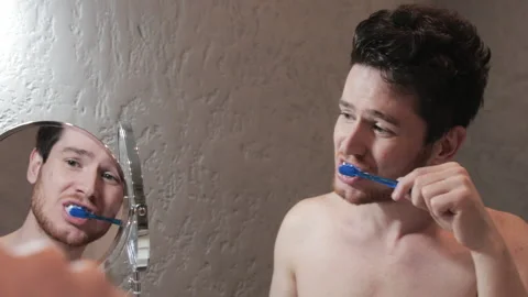 Handsome Man Brush Teeth Looking Face In Front Of Mirror. Sexy Man At Bathroom. Vidéo 206869031