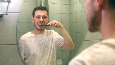Handsome man brushing his teeth Video stock 260452282