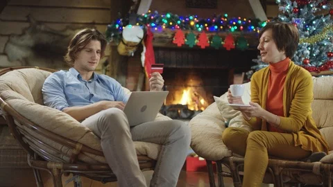 Handsome man buys online by using laptop and credit card on Christmas night Stock Footage 100018522