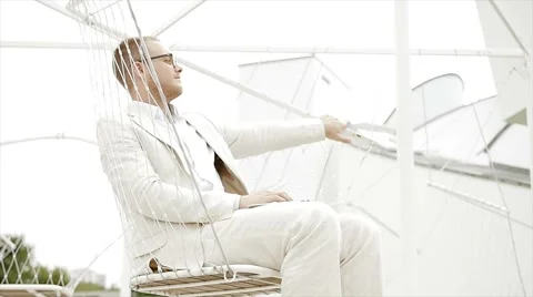 Handsome man in casual white suit relaxing outdoors. clean style Video stock 42949385