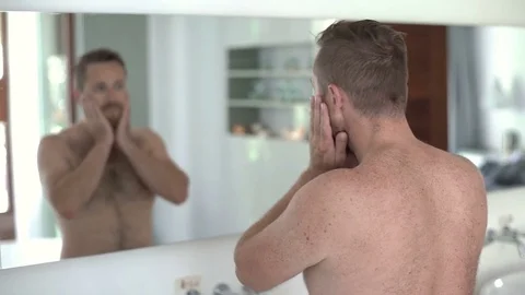 Handsome man checking his appearance in the mirror and smil Stock-Footage 81016418