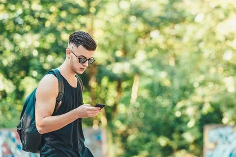 Handsome man checking mail on smartphone using application while spending time Stock Photos