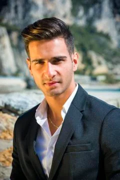 Handsome man in classical suit on beach Stock Photos
