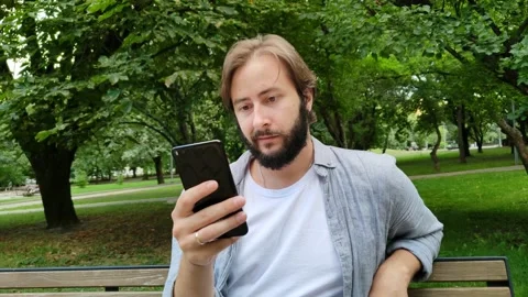 Handsome man communicates via smartphone messenger 스톡 동영상 208909636