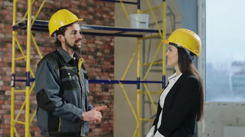 Handsome man constructor worker have a conversation with the woman architect Stock Footage 232590657