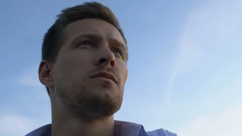 Handsome man contemplating about future on background of bright sky, close-up 動画素材 117194793