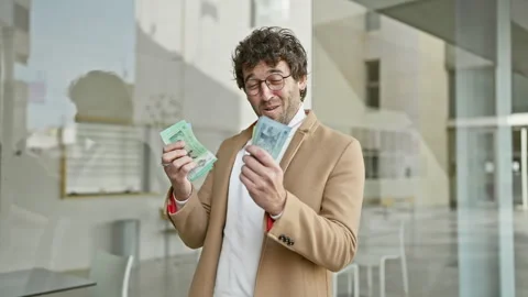 Handsome man counting malaysian ringgit on a city street, surrounded by urb.. Stock Footage 266476419