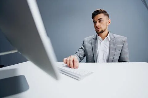 Handsome man documents on the table computer work emotions Gray background Stock Photos