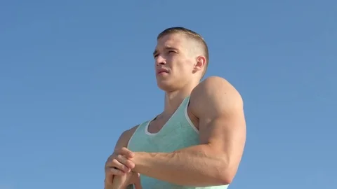Handsome man does morning exercise on the beach rotating hands warm up outdoors Video stock 84041543
