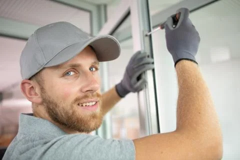 Handsome man does window installation Stock Photos