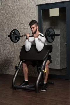 Handsome Man Doing Biceps Exercises In The Gym Stock Photos