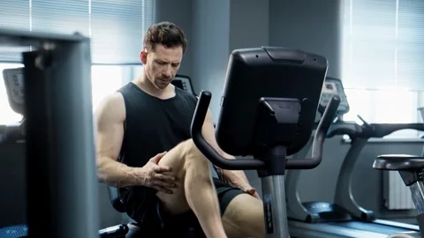 Handsome man doing cycling exercise in gym. Sporty man working hard Video stock 274985942