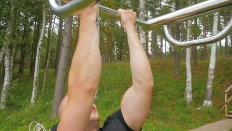 Handsome man doing pull ups in park. Slow motion Video stock 83819022