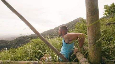 Handsome man doing push up exercise on green hill and tropical highlands Stock-Footage 107137225