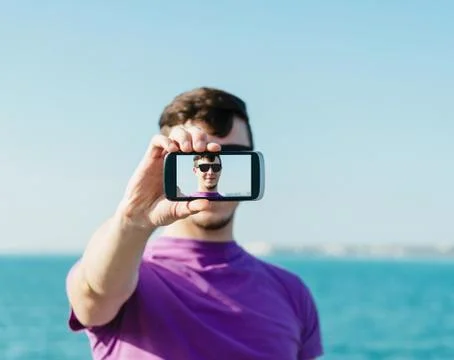 Handsome man doing a self-portrait with smartphone Stock Photos