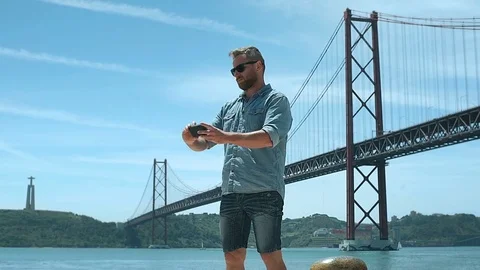 Handsome man doing selfies on smartphone while standing next to the river, stead Stock Footage