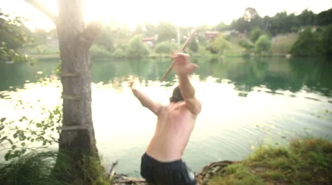 Handsome man doing somersault jump into river Stock Footage 59559765