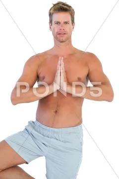 Handsome man doing the tree pose Stock Photos