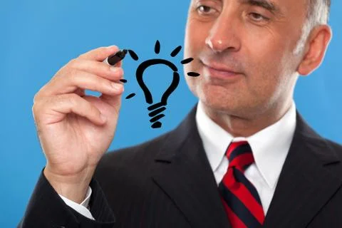 Handsome man drawing a light bulb Stock Photos