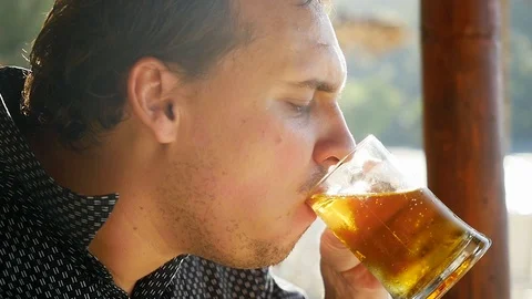 Handsome man is drinking beer in a cafe beach on tropical island. slow motion Vídeos de archivo 103578093
