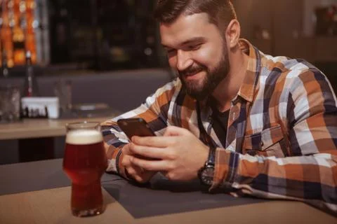 Handsome man drinking beer at the pub Stock Photos